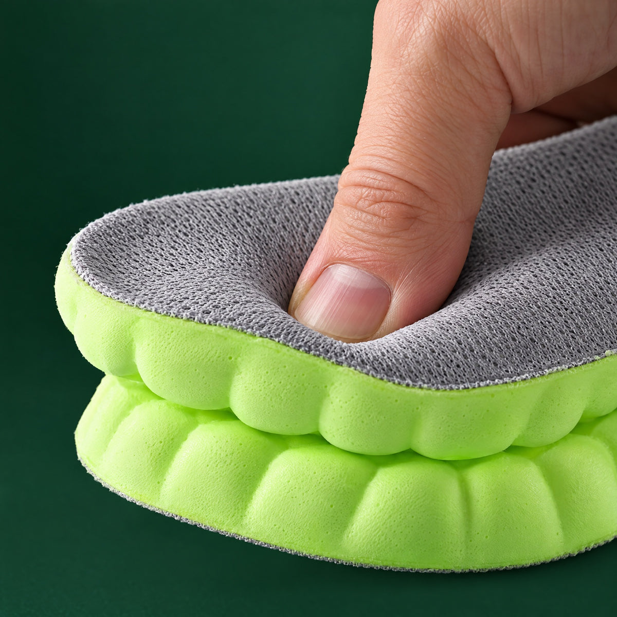 A thumb pressing into the heel of an EMPOFIT insole, the foam visibly compressing